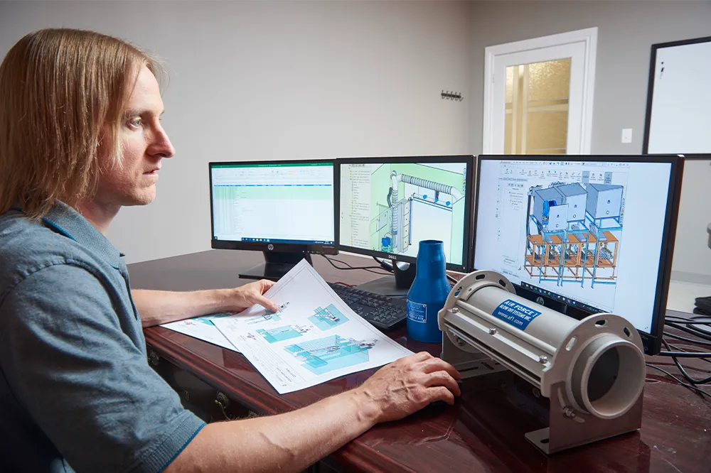 Engineer designing custom direct drive industrial blower system with CAD software